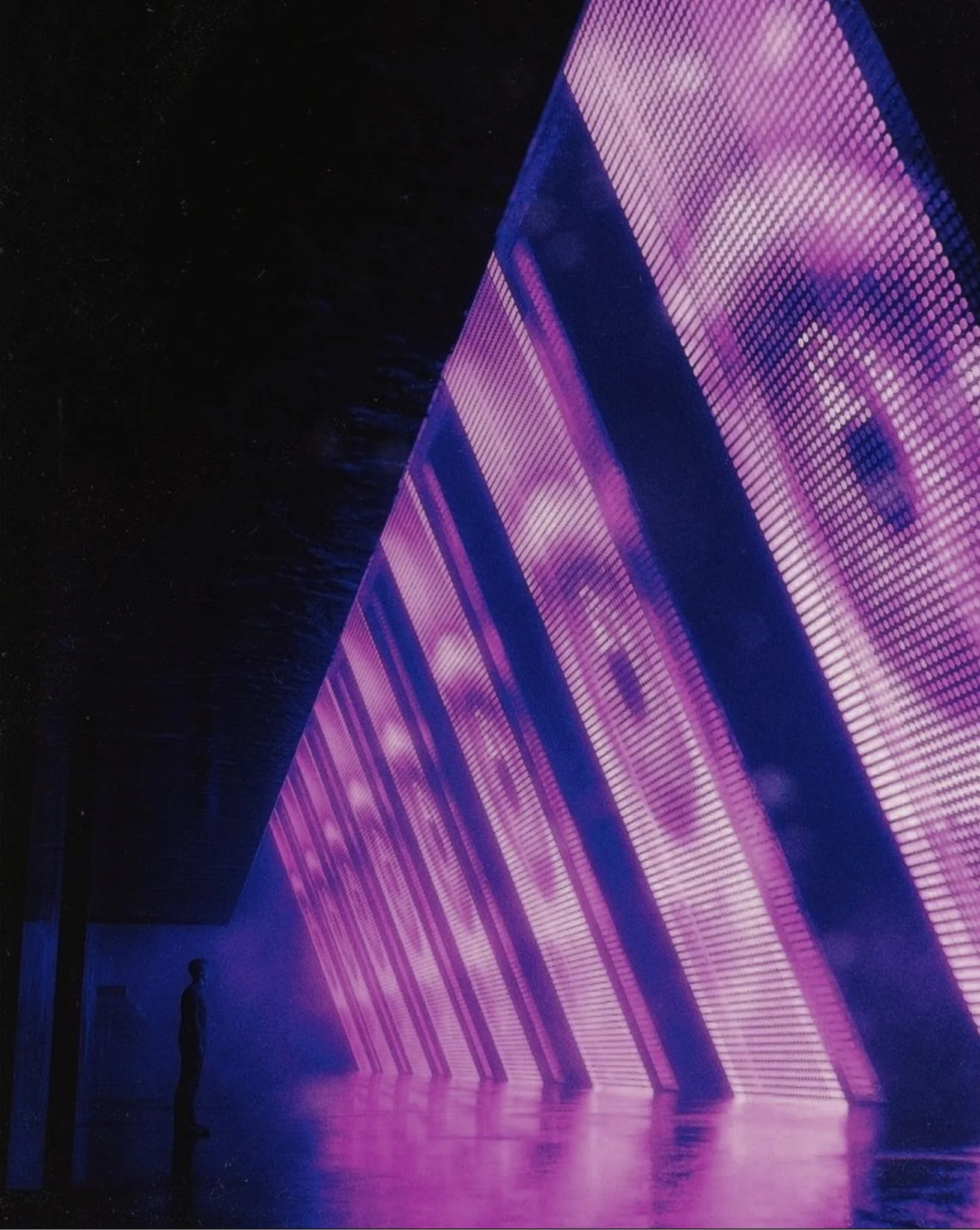 Angled violet LED panels reflecting on a dark polished floor